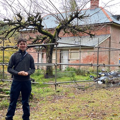 Young Ambassador Alex in front of scaffolding